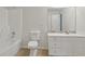 Bathroom with white vanity, tiled accent backsplash, shower/tub combo with white surround, and neutral paint at 2305 Lochinver Sw Ln, Conyers, GA 30094