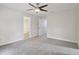 Spacious bedroom featuring neutral paint, grey carpet, a ceiling fan, and entry to a bathroom with shower at 2305 Lochinver Sw Ln, Conyers, GA 30094