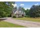 Inviting two-story home with manicured lawn, stone details, and a long driveway leading to the house at 2305 Lochinver Sw Ln, Conyers, GA 30094
