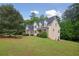 Two-story home featuring stone accents and lush landscaping, set on a spacious lot with mature trees at 2305 Lochinver Sw Ln, Conyers, GA 30094