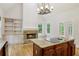 Kitchen with wooden cabinets, granite island cooktop, stainless steel appliances, and fireplace view at 2305 Lochinver Sw Ln, Conyers, GA 30094