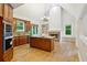 Open kitchen featuring wooden cabinets, granite island cooktop, and a view of the fireplace in the living room at 2305 Lochinver Sw Ln, Conyers, GA 30094