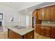 Open kitchen with granite island cooktop, wooden cabinets, and view of the living room with fireplace at 2305 Lochinver Sw Ln, Conyers, GA 30094