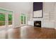 Bright living room with hardwood floors, fireplace, built-in shelving, and access to an outdoor deck at 2305 Lochinver Sw Ln, Conyers, GA 30094