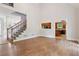 Open-concept living room with hardwood floors, staircase, and a view of the kitchen at 2305 Lochinver Sw Ln, Conyers, GA 30094