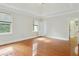 Bright main bedroom featuring tray ceilings, hardwood floors, and open doorway at 2305 Lochinver Sw Ln, Conyers, GA 30094