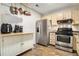 Eat-in kitchen features stainless steel appliances, ample counter space and hanging pot rack at 446 Teal Ct, Roswell, GA 30076