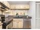 Galley kitchen open to the living room with stainless steel appliances and shaker cabinets at 446 Teal Ct, Roswell, GA 30076