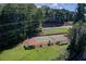 Aerial view of a well-maintained tennis court, surrounded by green grass and trees at 7098 Stonington Dr, Atlanta, GA 30328
