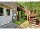 Brick exterior with a door, stairs to a deck, and backyard with lush greenery at 1459 Hickory Branch Nw Trl, Kennesaw, GA 30152