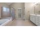 Bathroom featuring a walk-in shower, soaking tub, double sinks, and walk-in closet access at 1459 Hickory Branch Nw Trl, Kennesaw, GA 30152