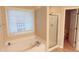 Well-lit bathroom featuring a soaking tub, glass-enclosed shower, and neutral tones at 4208 Royal Regency Nw Cir # 9, Kennesaw, GA 30144