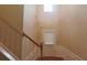Staircase leading to the upper level with wood railings and a view of the front door at 4208 Royal Regency Nw Cir # 9, Kennesaw, GA 30144