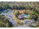 Aerial view of community amenities featuring a pool, clubhouse, tennis courts and playground surrounded by trees at 445 Big Bend Trl, Sugar Hill, GA 30518