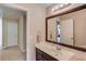 Bright bathroom with a single sink vanity, a large mirror and carpet hallway nearby at 445 Big Bend Trl, Sugar Hill, GA 30518