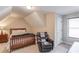 Bedroom with sloped ceilings, a wooden bed frame, and a comfortable reading chair at 445 Big Bend Trl, Sugar Hill, GA 30518