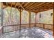 Covered back porch features a table and chairs; the space is surrounded by trees at 445 Big Bend Trl, Sugar Hill, GA 30518