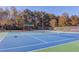 Well-maintained community tennis courts with a shelter and net, surrounded by a privacy fence and trees at 445 Big Bend Trl, Sugar Hill, GA 30518