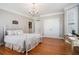 Cozy bedroom with hardwood floors, white iron bed frame, and modern chandelier at 639 Puckett Se Rd, Emerson, GA 30137