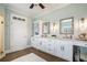Elegant bathroom featuring double vanity sinks, white cabinetry, and walk-in shower with wood look floors at 639 Puckett Se Rd, Emerson, GA 30137