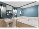 Charming blue bathroom with a pedestal sink, tiled walls, and a soaking tub at 10 Wyndham Dr, Sandy Springs, GA 30328
