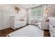 Cozy Bedroom featuring a crib, rocking chair, and stylish decor at 10 Wyndham Dr, Sandy Springs, GA 30328