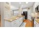 Well-appointed kitchen featuring granite countertops, stainless appliances, white cabinetry and hardwood flooring at 110 Apple Blossom Ln, Fayetteville, GA 30215