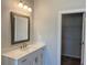 Bathroom featuring a single vanity with white counter and a wood-framed mirror at 146 Birch Tree Way, Cumming, GA 30040