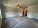Large bedroom with a ceiling fan, plush carpeting, and large windows with neighborhood views at 146 Birch Tree Way, Cumming, GA 30040