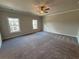 Large bedroom boasts plush carpeting, ceiling fan, and windows allowing natural light to fill the room at 146 Birch Tree Way, Cumming, GA 30040