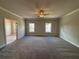 Spacious bedroom featuring neutral carpet, ceiling fan, and two windows with views of the neighborhood at 146 Birch Tree Way, Cumming, GA 30040