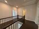 View of the upstairs hallway with dark wood flooring and a wood banister overlooking the stairs at 146 Birch Tree Way, Cumming, GA 30040