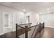 Bright hallway featuring hardwood floors, a wooden railing, and access to various rooms at 146 Birch Tree Way, Cumming, GA 30040