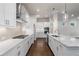 Open kitchen with a large quartz island, stainless steel appliances, and modern pendant lights at 146 Birch Tree Way, Cumming, GA 30040