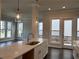 Modern kitchen with a center island, white cabinets, marble countertops, and a view of the living area at 146 Birch Tree Way, Cumming, GA 30040