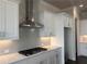 The bright kitchen includes stainless appliances, white shaker cabinets, quartz countertops and a tiled backsplash at 146 Birch Tree Way, Cumming, GA 30040