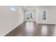 Living room featuring hardwood floors, white trim, an exterior door, and windows with neighborhood views at 146 Birch Tree Way, Cumming, GA 30040