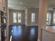 Open-concept living room featuring hardwood floors, large windows, and views to the kitchen at 146 Birch Tree Way, Cumming, GA 30040