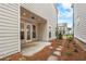 Covered concrete patio area with stone path leading to backyard, surrounded by pine straw and siding at 146 Birch Tree Way, Cumming, GA 30040