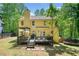 Exterior of a two story yellow home featuring large backyard, deck, and green surroundings at 160 Wentworth Dr, Canton, GA 30114