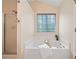 Bathroom featuring a soaking tub with a window view, plus a separate shower and neutral walls at 160 Wentworth Dr, Canton, GA 30114