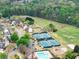 Aerial view captures community with tennis courts, pool, playground, and green spaces at 1900 Chattahoochee Run Dr, Suwanee, GA 30024