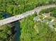 Aerial view showing the river, the highway bridge, houses nestled among lush trees at 1900 Chattahoochee Run Dr, Suwanee, GA 30024