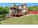 Beautiful backyard featuring a spacious lawn, a screened porch, and a wooden deck at 1900 Chattahoochee Run Dr, Suwanee, GA 30024