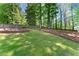 Lush, green backyard with terraced landscaping and mature trees providing shade and privacy at 1900 Chattahoochee Run Dr, Suwanee, GA 30024
