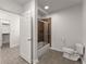 Bathroom featuring a toilet, bathtub with glass doors, and closet at 1900 Chattahoochee Run Dr, Suwanee, GA 30024
