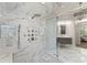Bright, spacious marble bathroom with a glass shower, multiple shower heads, and a modern chandelier at 1900 Chattahoochee Run Dr, Suwanee, GA 30024