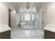 Beautifully designed bathroom with a glass shower, a soaking tub, and marble floors at 1900 Chattahoochee Run Dr, Suwanee, GA 30024