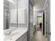Bright bathroom featuring a white vanity, storage cabinets, and tiled floors leading to the bedroom at 1900 Chattahoochee Run Dr, Suwanee, GA 30024