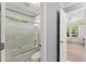 This bathroom showcases a tub with glass door with gray walls next to an open bedroom at 1900 Chattahoochee Run Dr, Suwanee, GA 30024